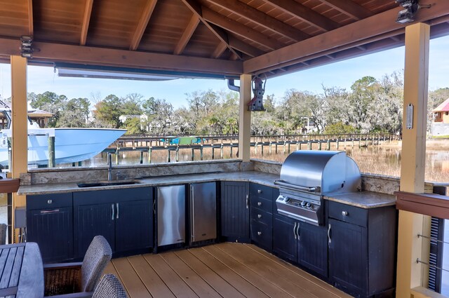 deck with exterior kitchen, area for grilling, sink, and a gazebo