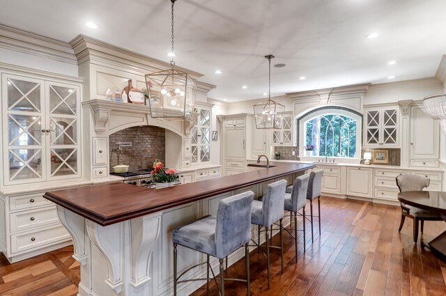 kitchen featuring an island with sink, a kitchen breakfast bar, and decorative light fixtures