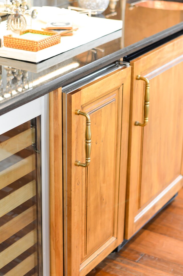 room details with beverage cooler and dark hardwood / wood-style floors