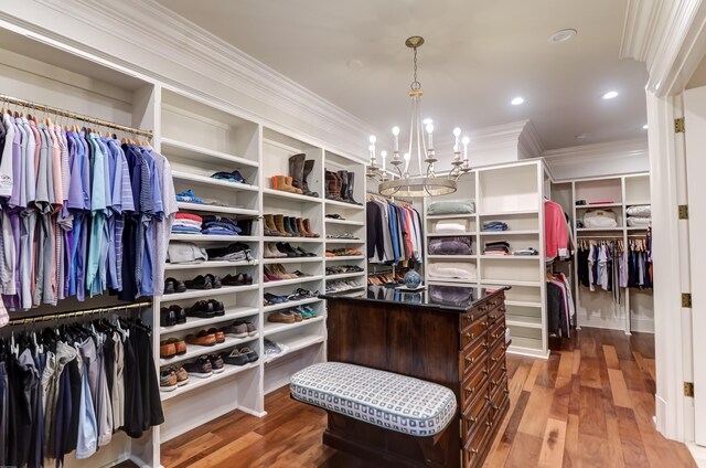 spacious closet featuring an inviting chandelier and hardwood / wood-style flooring