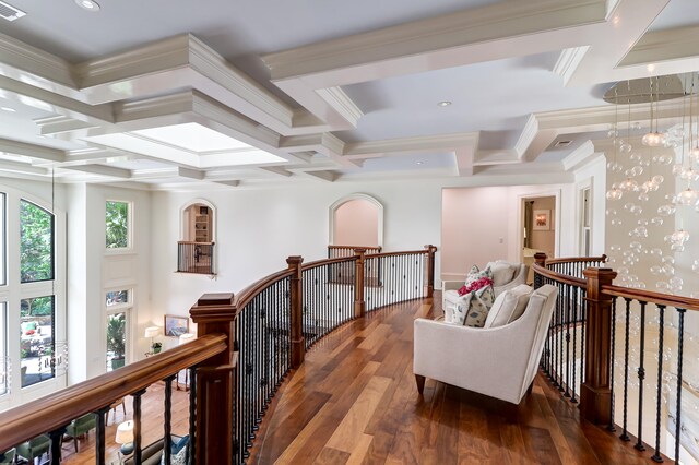 hall featuring beam ceiling, coffered ceiling, a chandelier, ornamental molding, and dark hardwood / wood-style floors