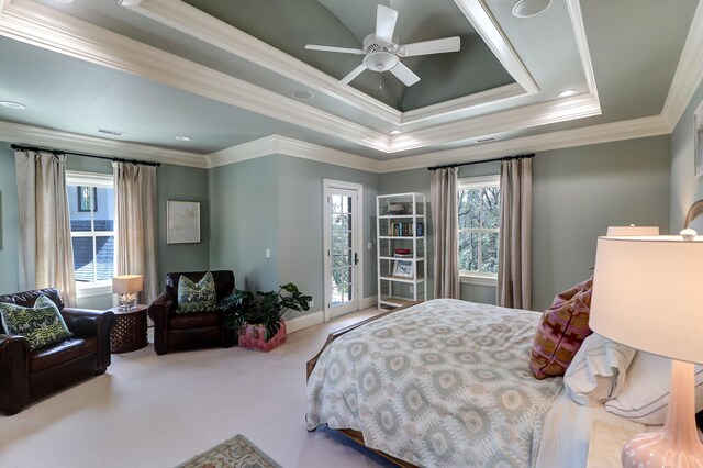 carpeted bedroom with multiple windows, a raised ceiling, and ornamental molding