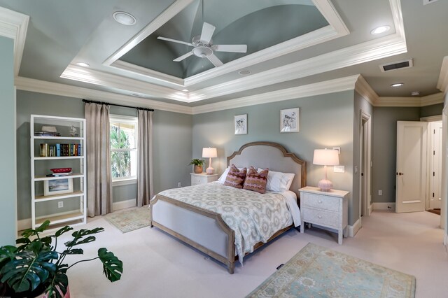 bedroom featuring light carpet, a tray ceiling, ornamental molding, and ceiling fan