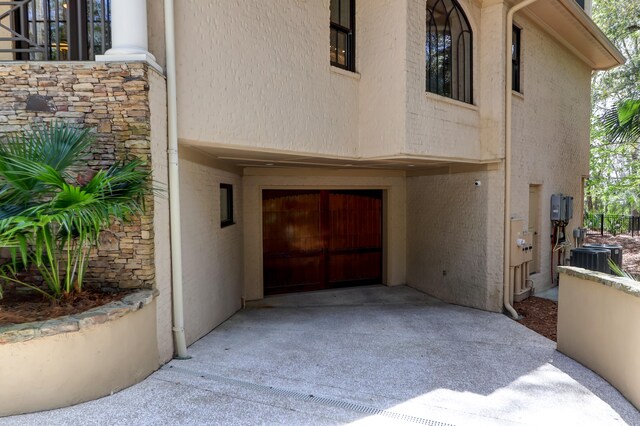 property entrance featuring central air condition unit and a patio area