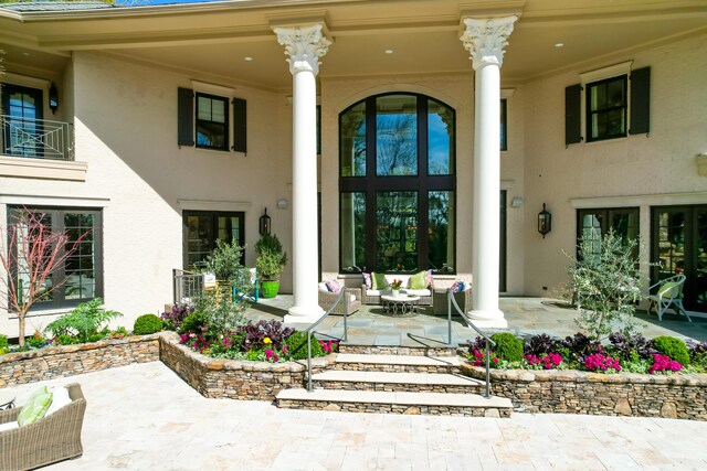 entrance to property with a patio, french doors, and an outdoor living space