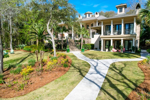 view of front of house with a balcony and a front lawn