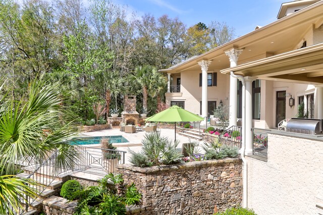 view of swimming pool with a patio, exterior kitchen, and a fireplace