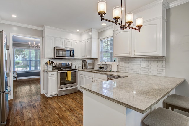 2916 Shadow Ln, North Charleston, SC 29406 - kitchen with a chandelier, appliances with stainless steel finishes, a sink, white cabinetry, and ornamental molding