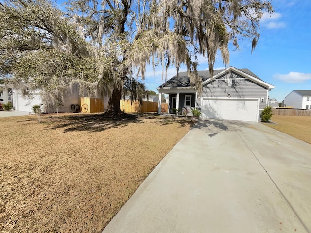 view of front of property featuring a garage, concrete driveway, and fence