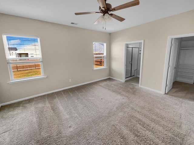 unfurnished bedroom featuring ensuite bath, carpet flooring, baseboards, and visible vents