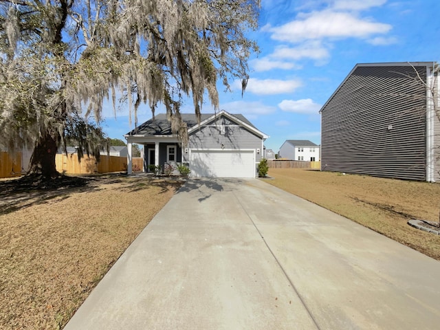 view of front of home featuring an attached garage, concrete driveway, and fence