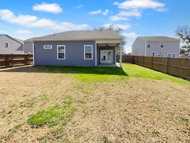 rear view of house featuring a yard and a fenced backyard