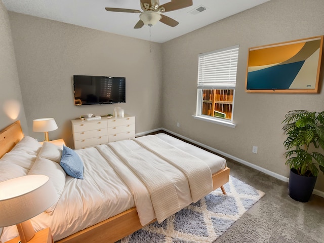 carpeted bedroom with visible vents, baseboards, and a ceiling fan