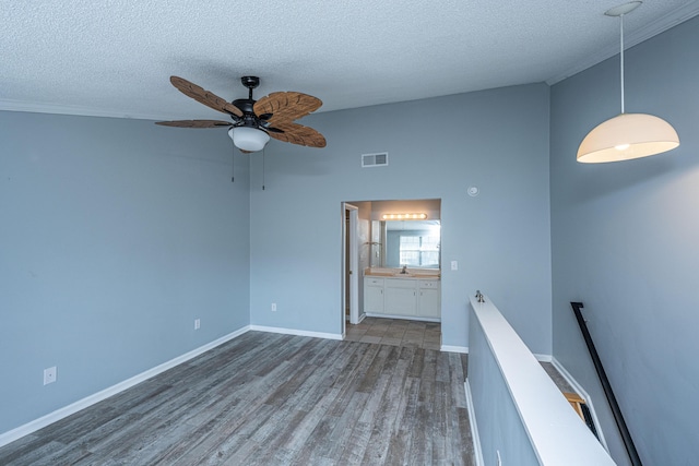 unfurnished room with ceiling fan, dark hardwood / wood-style floors, and a textured ceiling