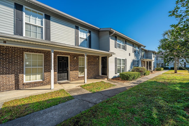 townhome / multi-family property featuring a front lawn