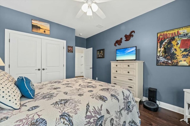 bedroom with dark wood-type flooring, ceiling fan, and a closet