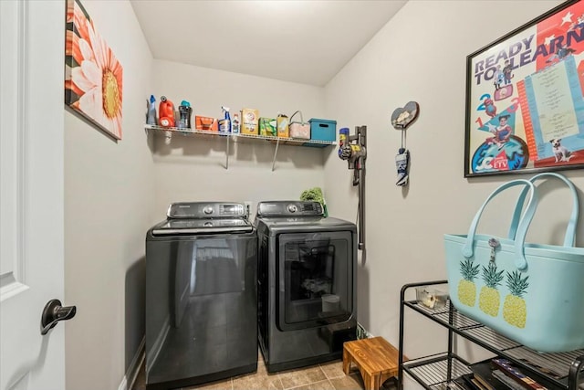 clothes washing area featuring light tile patterned floors and washing machine and clothes dryer