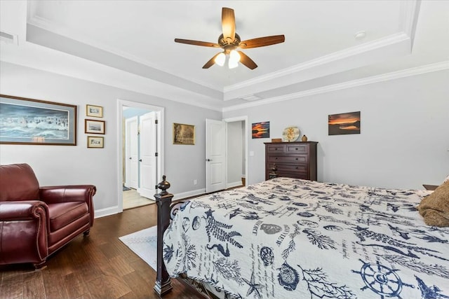 bedroom featuring ceiling fan, ornamental molding, a tray ceiling, and dark hardwood / wood-style flooring