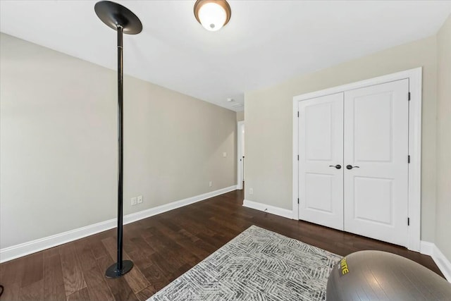 bedroom with dark hardwood / wood-style flooring and a closet