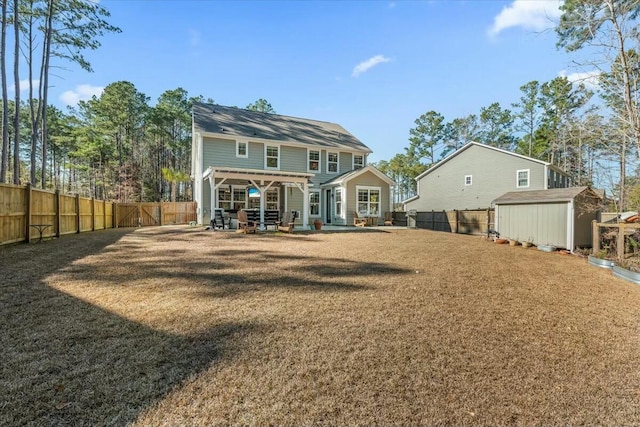 back of property featuring a storage shed, a yard, a pergola, and a patio area