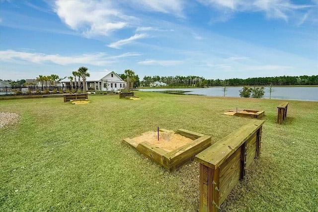 view of property's community with a lawn and a water view