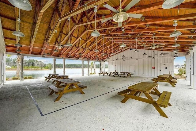 interior space featuring vaulted ceiling with beams, plenty of natural light, and a water view