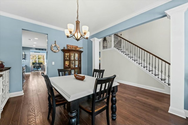 dining room with an inviting chandelier, dark wood-type flooring, ornamental molding, and ornate columns