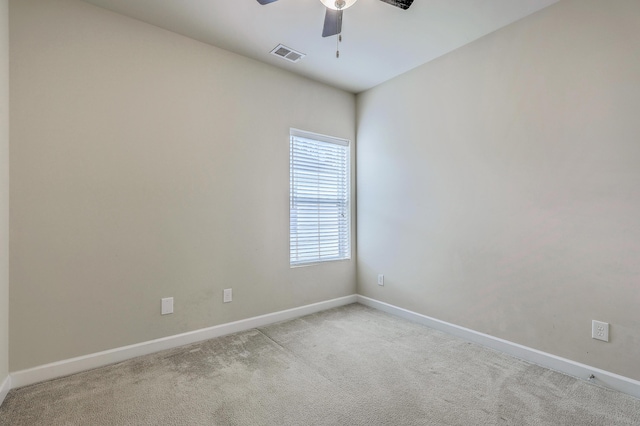 spare room with baseboards, visible vents, a ceiling fan, and light colored carpet