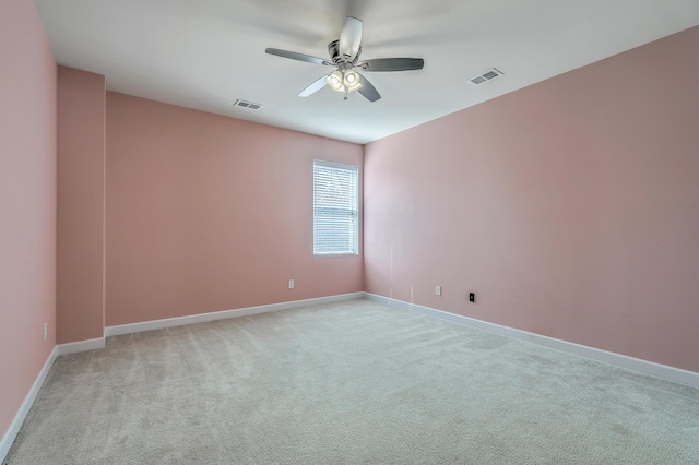 empty room featuring light carpet, baseboards, visible vents, and a ceiling fan