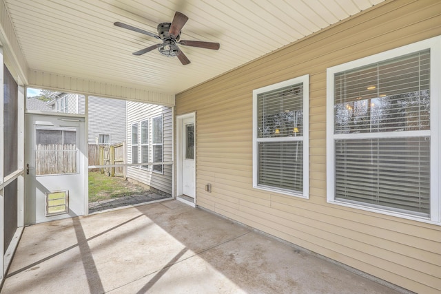 unfurnished sunroom with ceiling fan