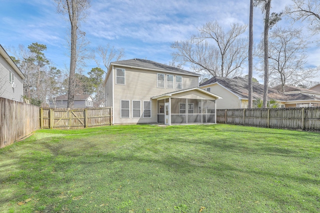 rear view of house with a lawn, a fenced backyard, and a sunroom