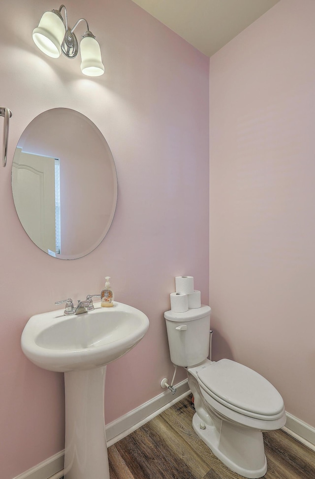 bathroom featuring wood finished floors, toilet, and baseboards