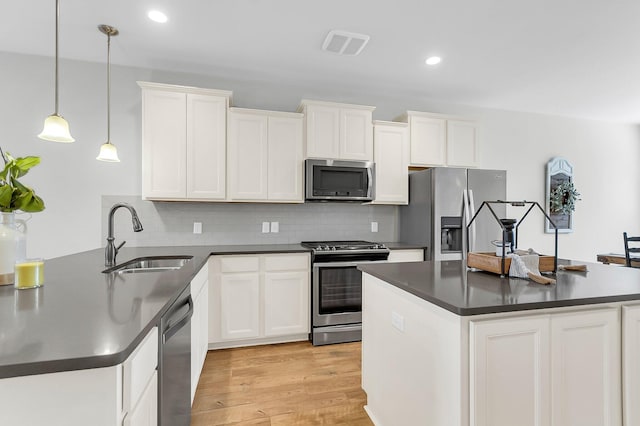 kitchen featuring appliances with stainless steel finishes, sink, and white cabinets