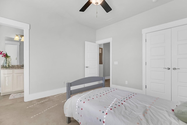 bedroom featuring ensuite bath, light colored carpet, a closet, and ceiling fan