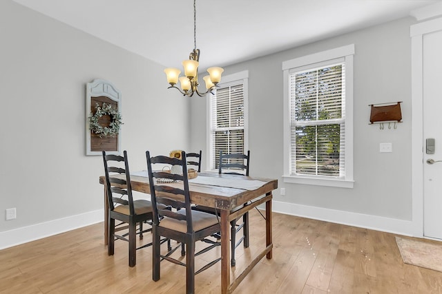 dining area with an inviting chandelier and light wood-type flooring