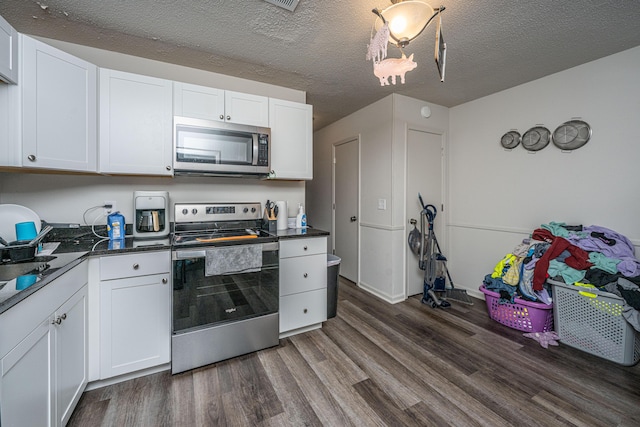 306 Crestview Dr Unit C, Summerville, SC 29485 - kitchen with appliances with stainless steel finishes, dark wood-style floors, dark countertops, white cabinetry, and a textured ceiling