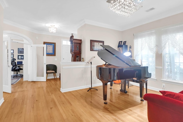 sitting room featuring light wood-style floors, an inviting chandelier, crown molding, and baseboards