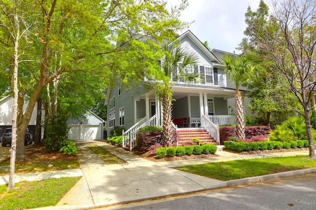 view of front of home with an outbuilding, a porch, a garage, and concrete driveway