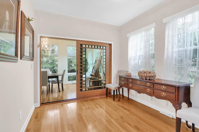 living area featuring light wood-type flooring and baseboards