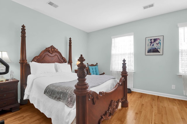 bedroom with light wood-type flooring, baseboards, and visible vents