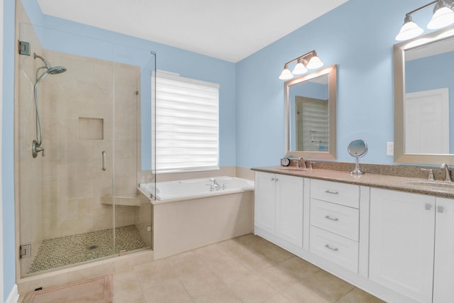 bathroom featuring double vanity, a garden tub, a sink, and a stall shower