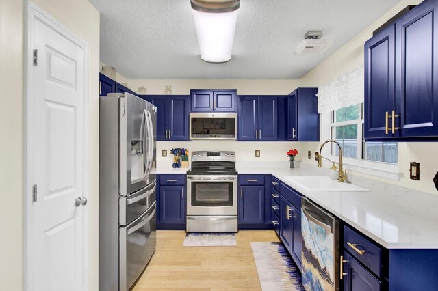 104 Lancaster Ct, Goose Creek, SC 29445 - kitchen with appliances with stainless steel finishes, blue cabinetry, light wood finished floors, light countertops, and a textured ceiling