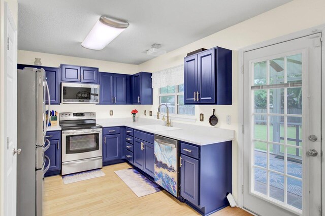 104 Lancaster Ct, Goose Creek, SC 29445 - kitchen with appliances with stainless steel finishes, blue cabinets, light wood-type flooring, and light countertops
