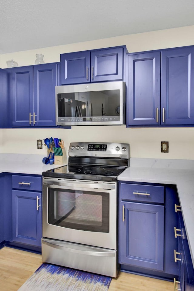 104 Lancaster Ct, Goose Creek, SC 29445 - kitchen featuring appliances with stainless steel finishes, blue cabinetry, and light wood-style floors