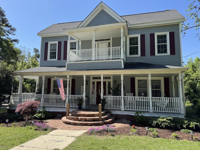 view of front of property featuring a porch, roof with shingles, and a balcony