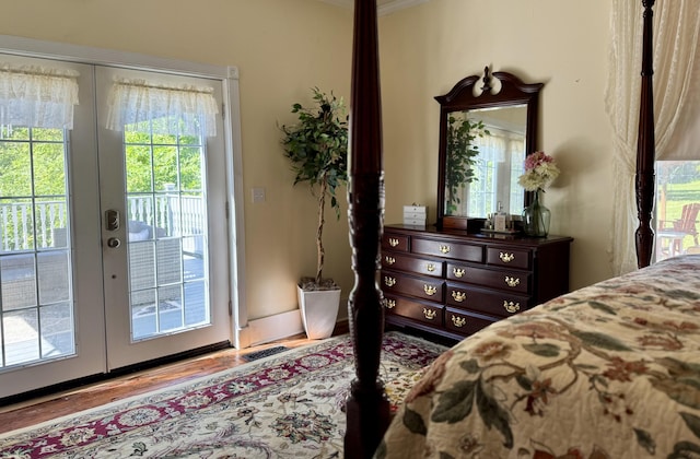 bedroom featuring french doors, access to outside, and wood finished floors