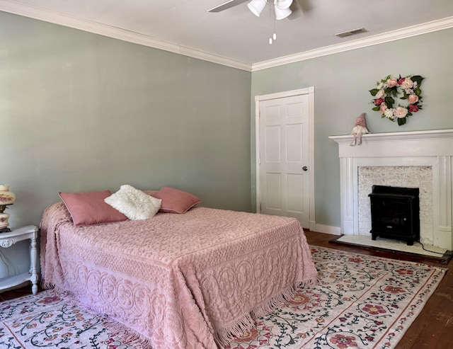 bedroom with ornamental molding, wood finished floors, ceiling fan, and baseboards
