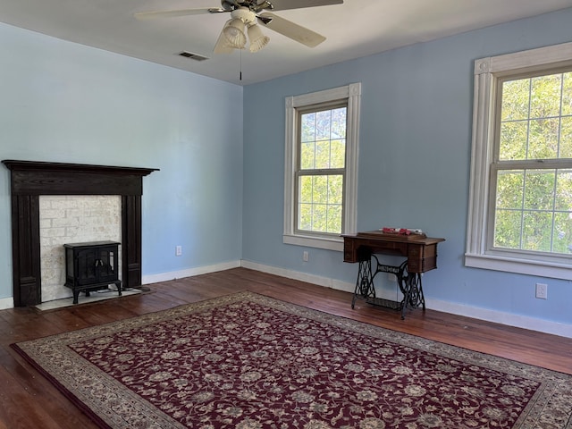 living area with wood-type flooring, a ceiling fan, and baseboards