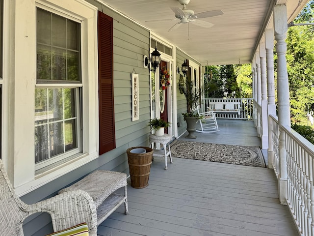 wooden terrace with covered porch and a ceiling fan