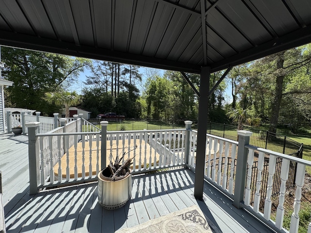 wooden terrace featuring view of wooded area